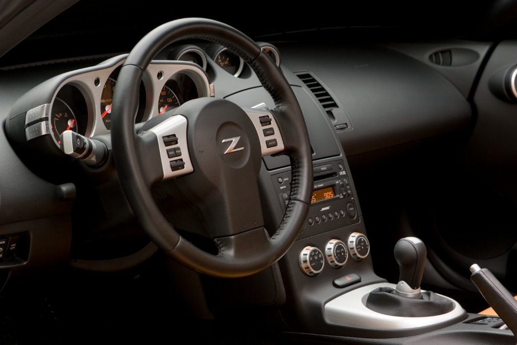 Driver cockpit of the Nissan 350Z featuring the three-spoke steering wheel with Z badge and 6-speed manual shifter