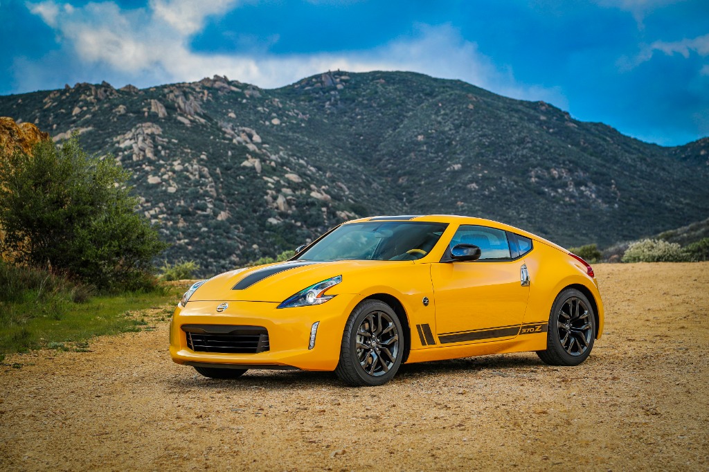 Nissan 370Z Heritage Edition in bright yellow with contrasting graphics set against rugged terrain