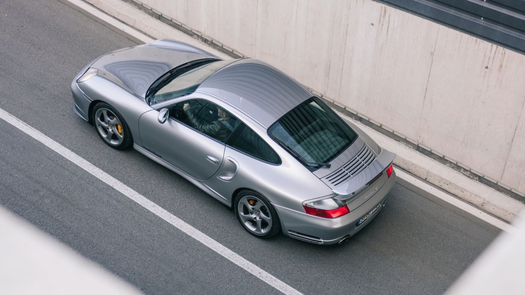 High-angle overhead view of a Porsche 911 (996) Turbo S driving dynamically on a winding road